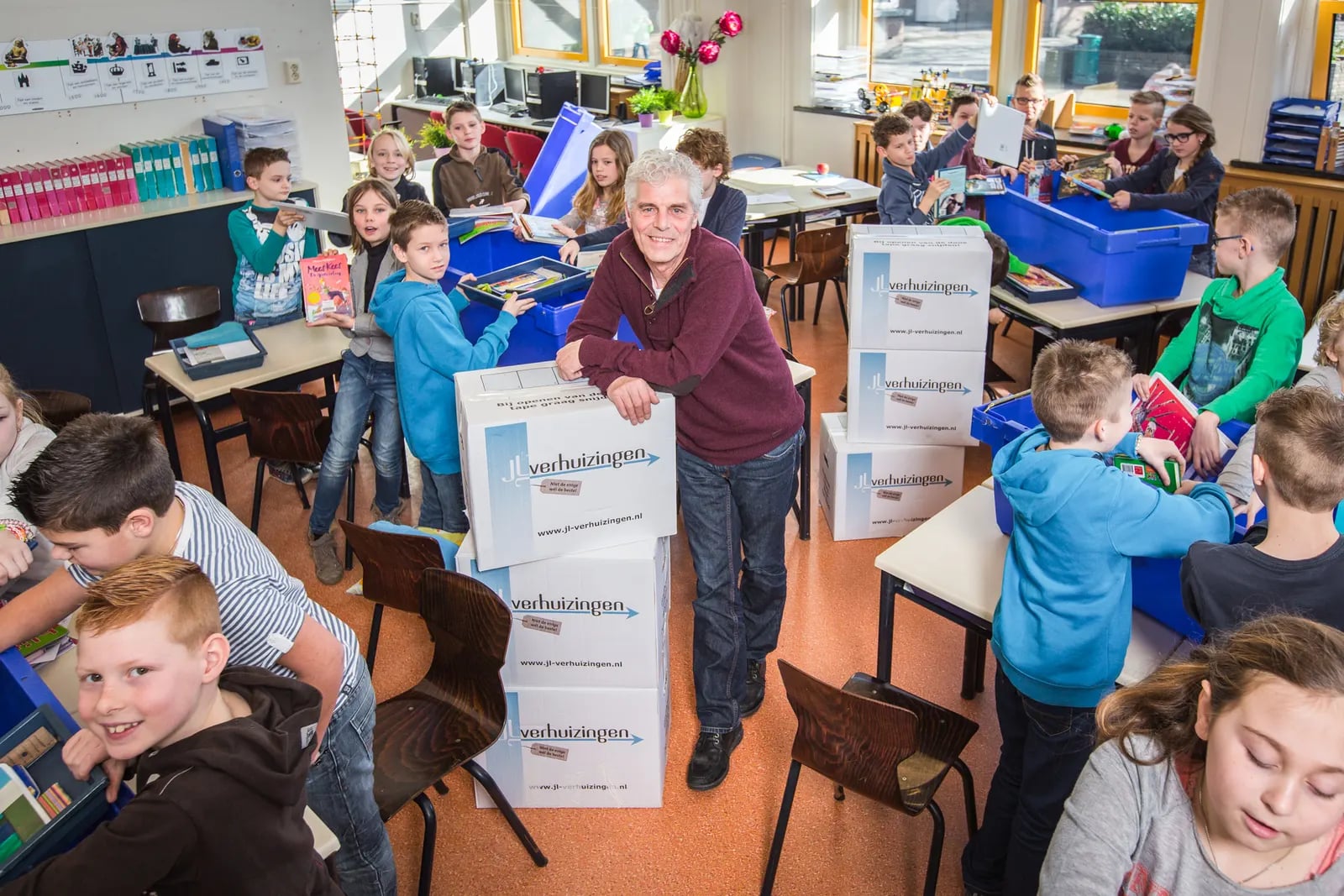 Volle klas met verhuisdozen van JL tijdens een schoolverhuizing